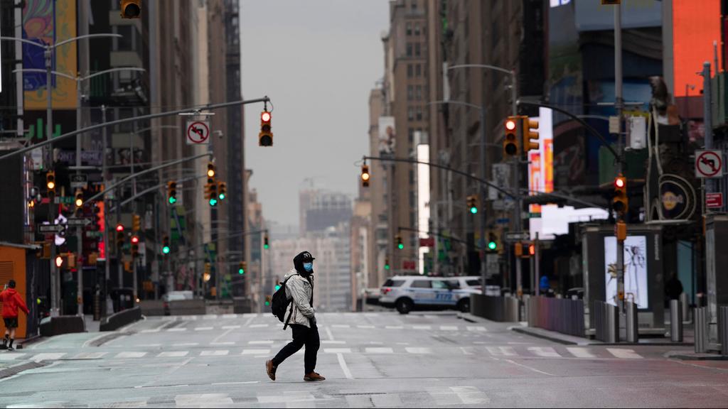  A man crosses a street of the empty NYC 