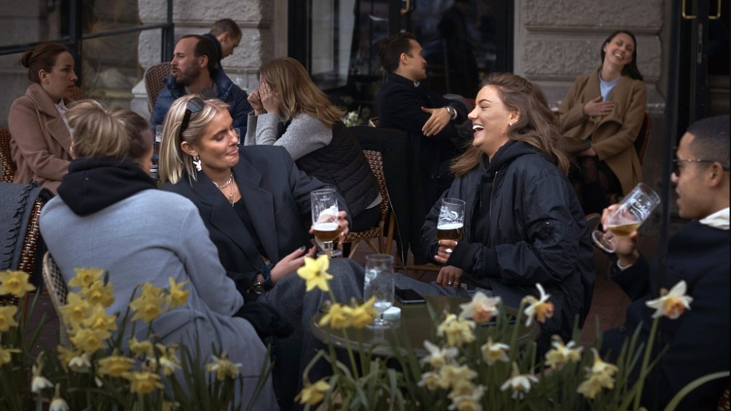 People chat and drink outside a bar in Stockholm, Sweden 