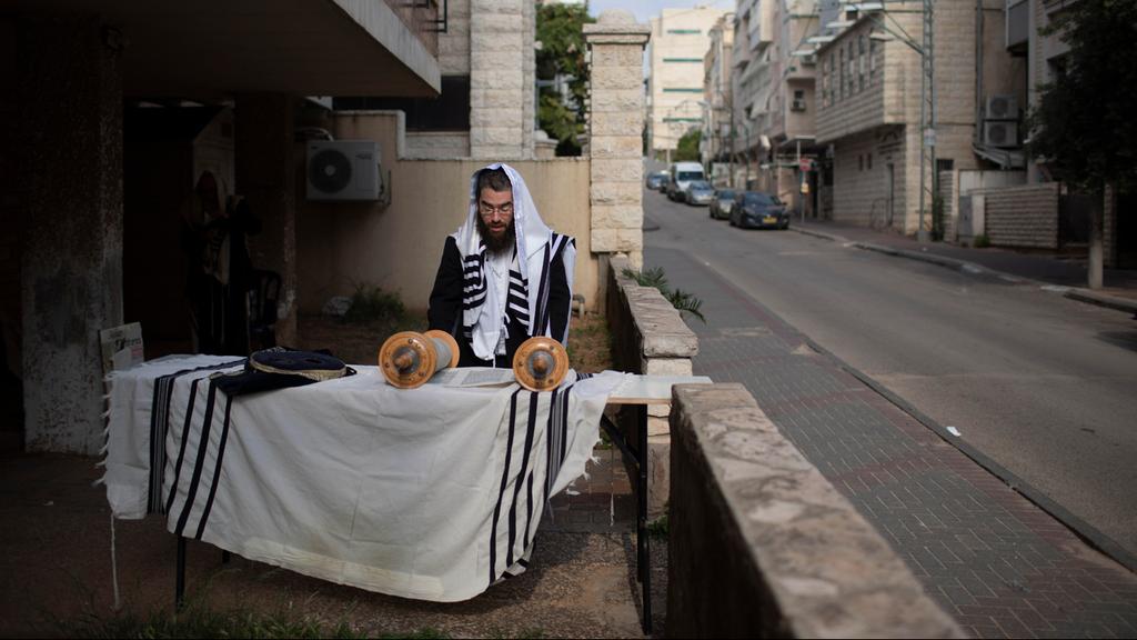  A man celebrates Passover ouside among Bnei Brak's empty streets 