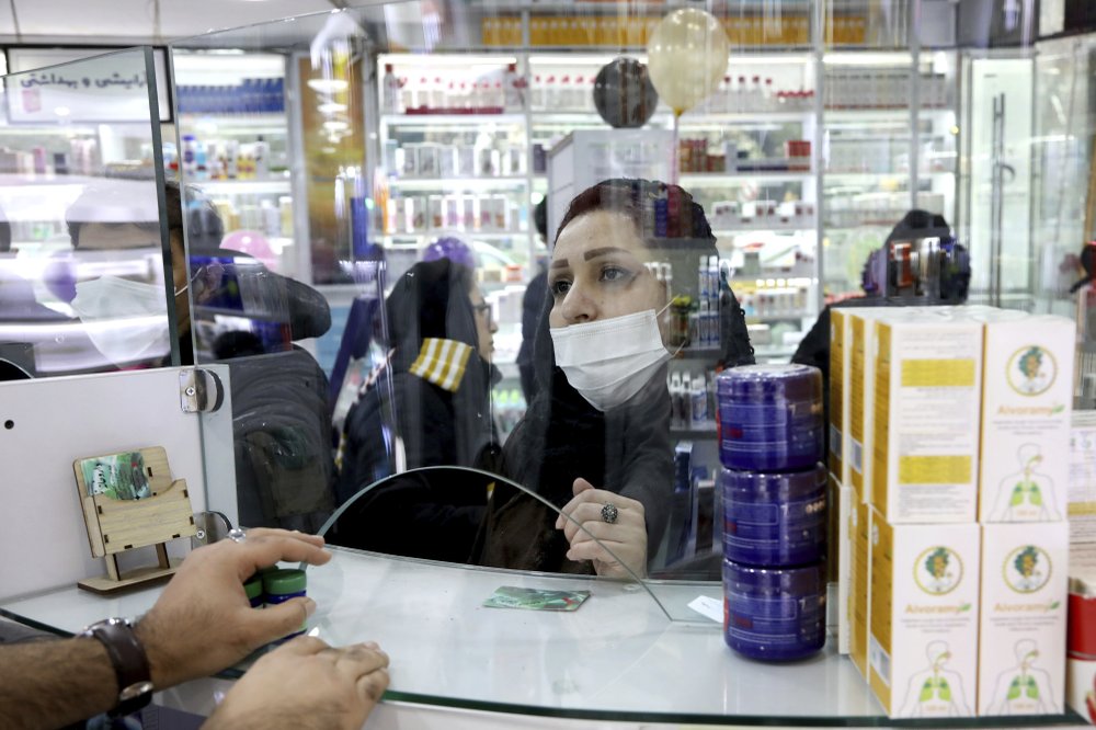 A customer talks with a pharmacist at a drugstore in downtown Tehran 