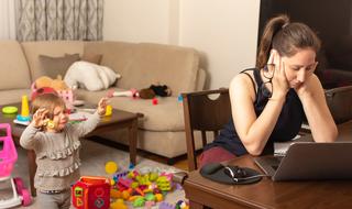 אישה מתקשה לשמור על ריכוז בעבודה מהיבת עם ילדים