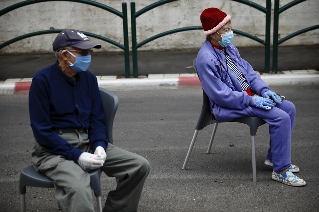Holocaust survivors Manya Herman, left, and Eliezer Rabinovich wear masks and gloves as they keep a distance while attending an annual Holocaust memorial ceremony 