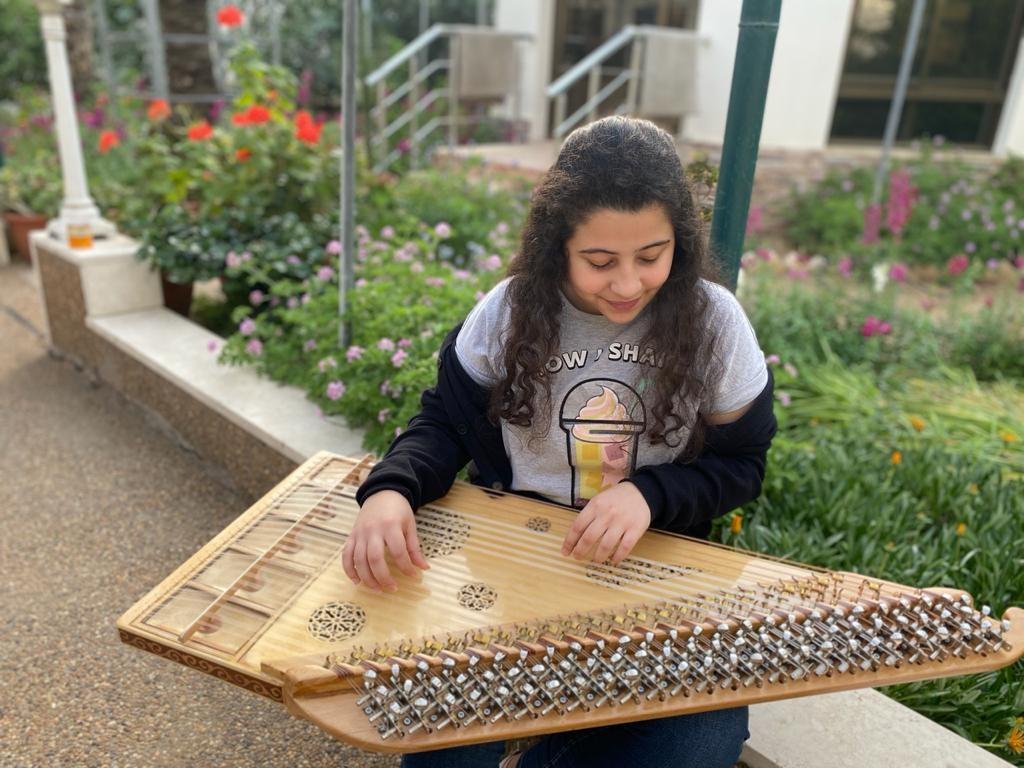 Zaina Alagha playing zither at her house in central Gaza City