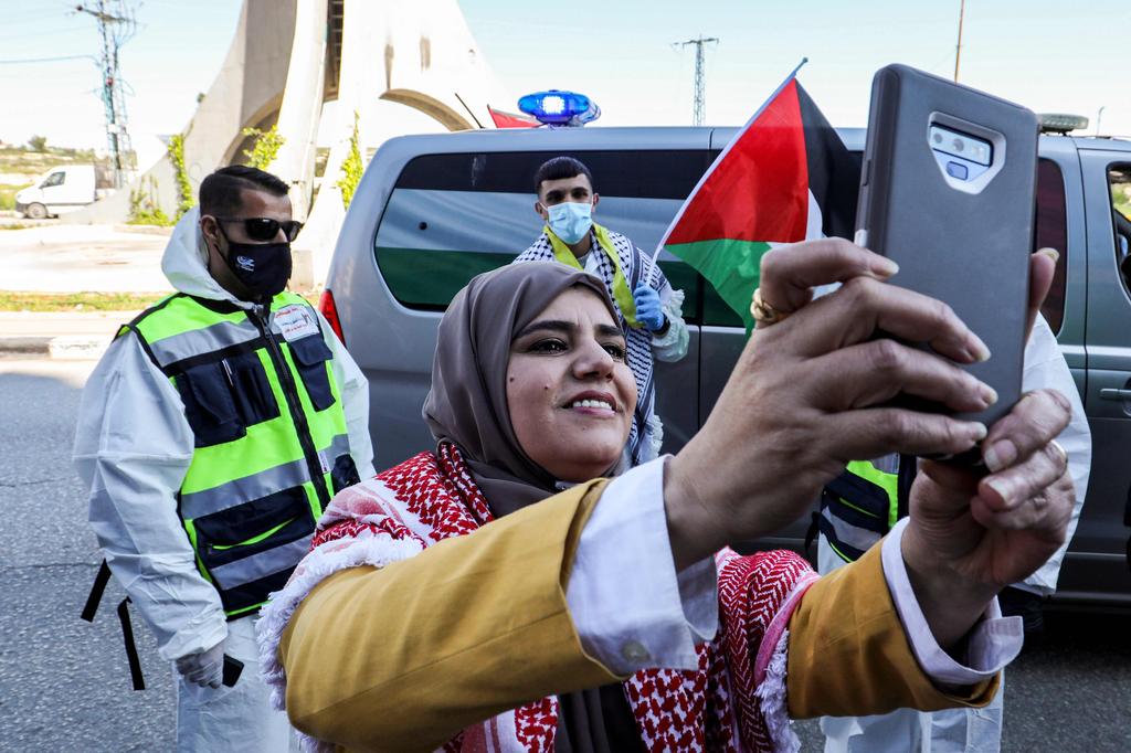 A family member of Amir Naji (C, back), who released by Israel from prison, uses her phone to pose for a 'selfie' picture with him upon his arrival 