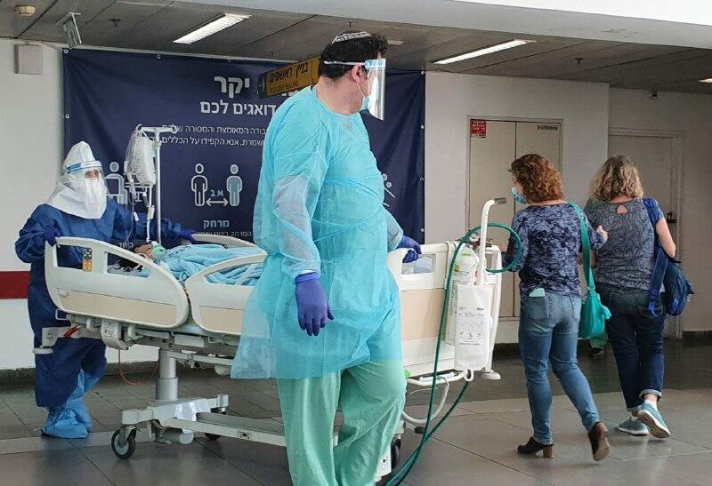 Medics in protective gear against coronavirus with a patient at Ichilov Hospital in Tel Aviv  