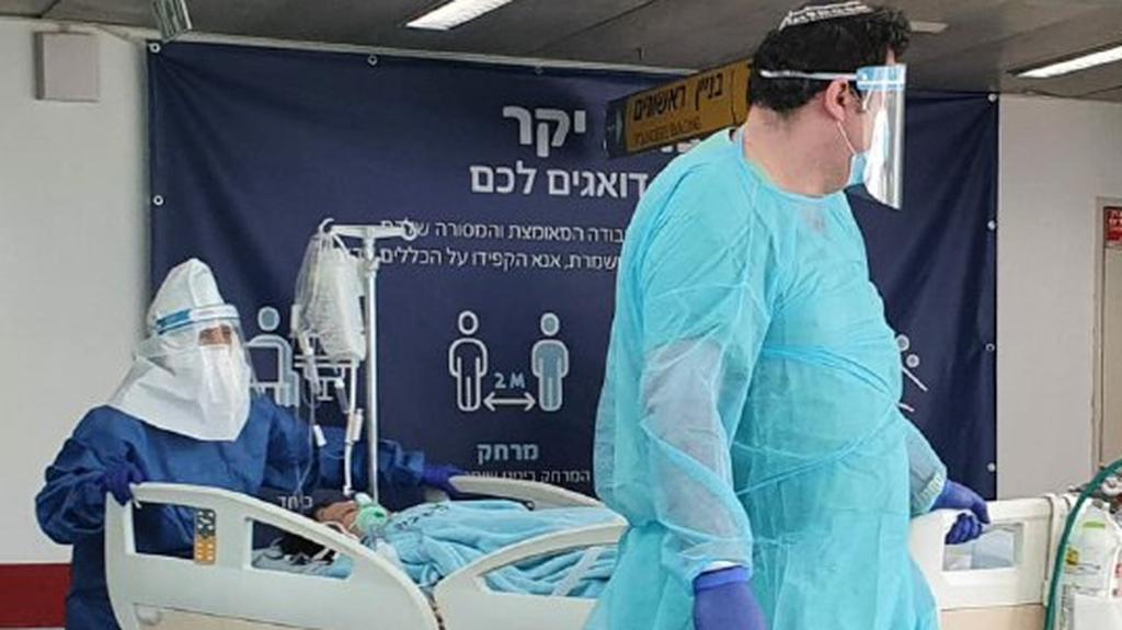 Medics in protective gear against coronavirus with a patient at Ichilov Hospital in Tel Aviv  