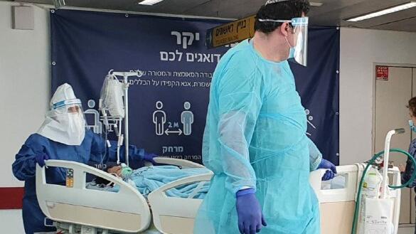 Medics in protective gear against coronavirus with a patient at Ichilov Hospital in Tel Aviv  