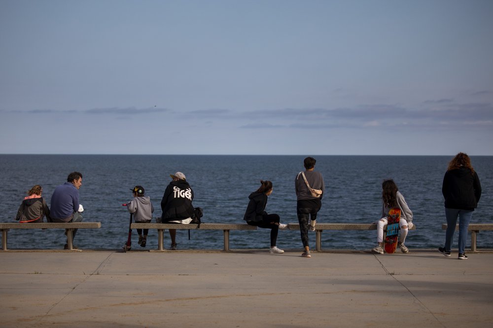 People look at the Mediterranean sea in Barcelona, Spain 