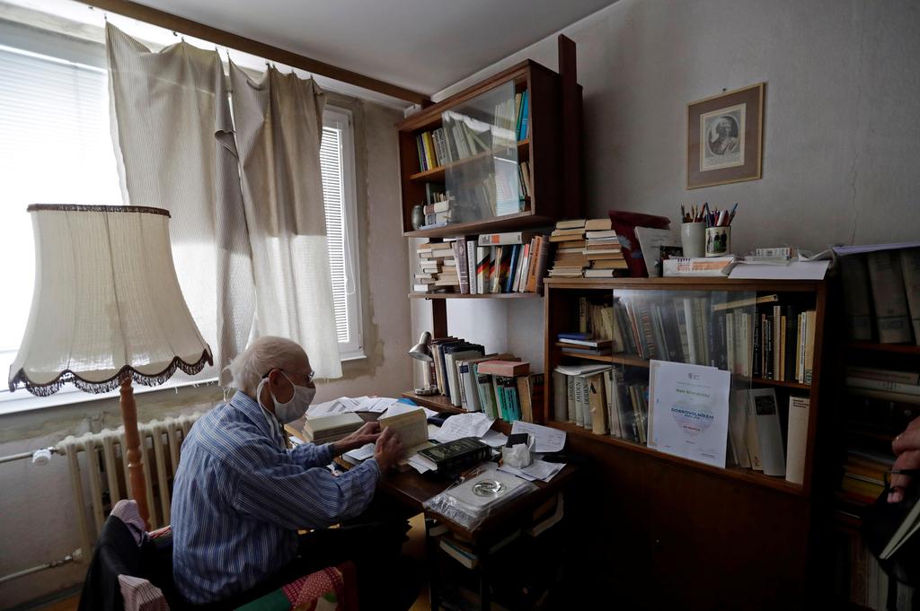 Petr Brandejsky, a 90-year-old Holocaust survivor, reads a book at his apartment during coronavirus outbreak in Prague, Czech Republic