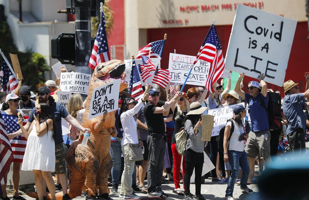 Protesters stand along Mission Blvd. during A Day of Liberty rally in Pacific Beach in San Diego 