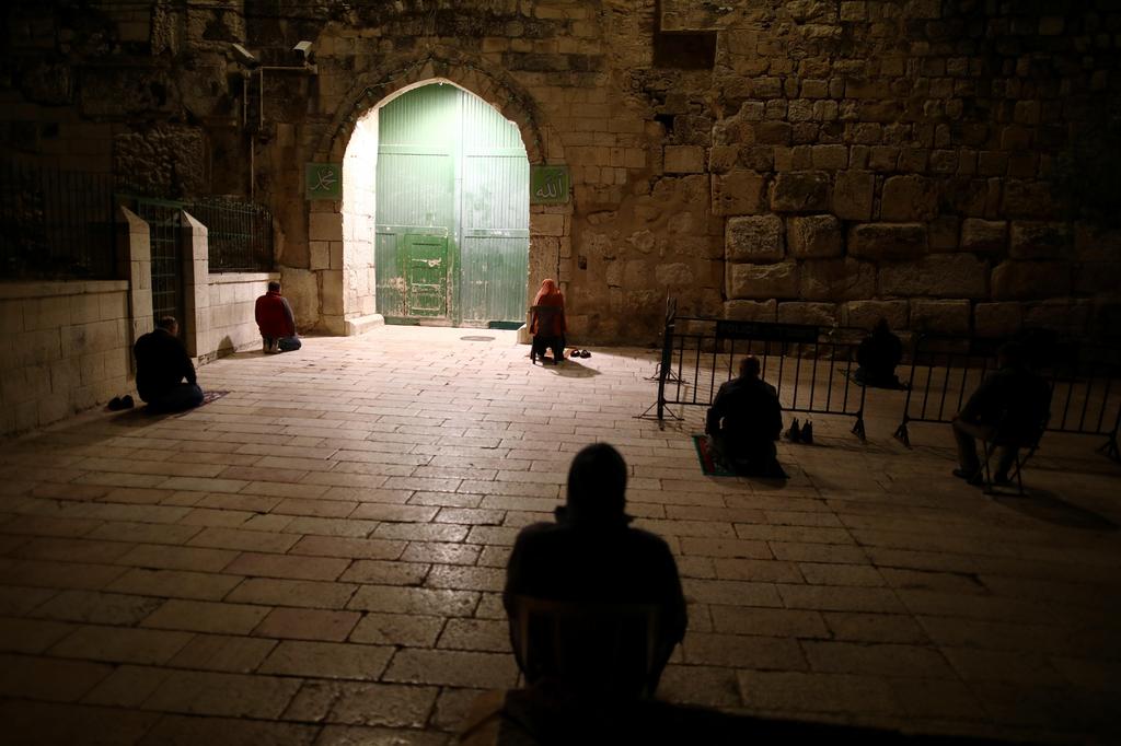 Muslim worshippers pray near the closed gate of the compound housing Al-Aqsa mosque at Jerusalem's Old City 