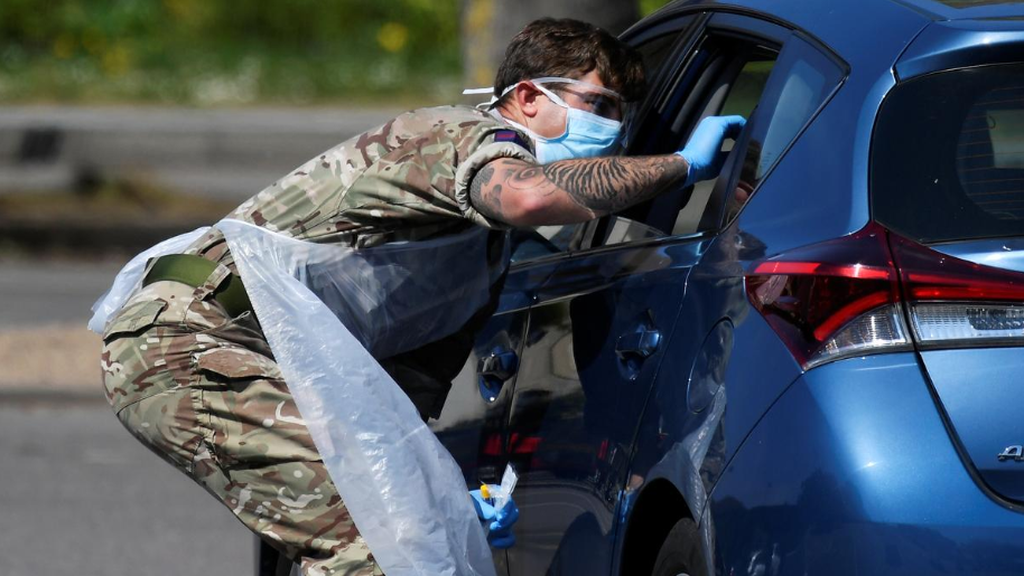A member of the military tests a person at a coronavirus test centre in the car park of Chessington World of Adventures, Chessington, Britain 