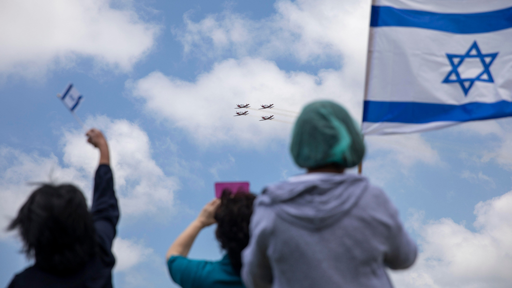 People holding Israeli flags during the Independence Day flyby 