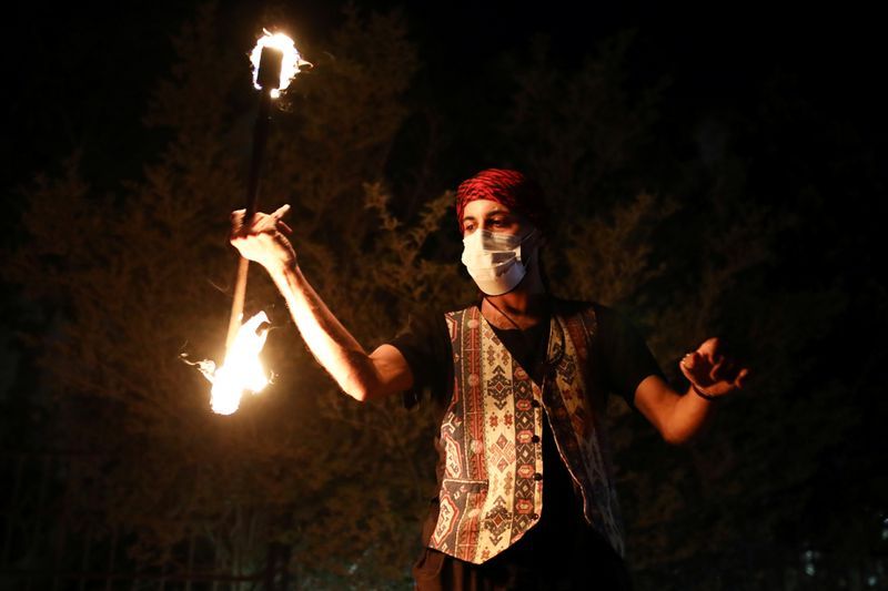 A man plays with fire on a festive Ramadan float as it drives through a street in East Jerusalem to bring celebrations to people under coronavirus disease (COVID-19) movement restrictions 