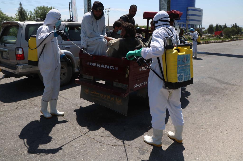 Workers spray disinfectant on a road amid the ongoing coronavirus COVID-19 pandemic in Herat, Afghanistan 