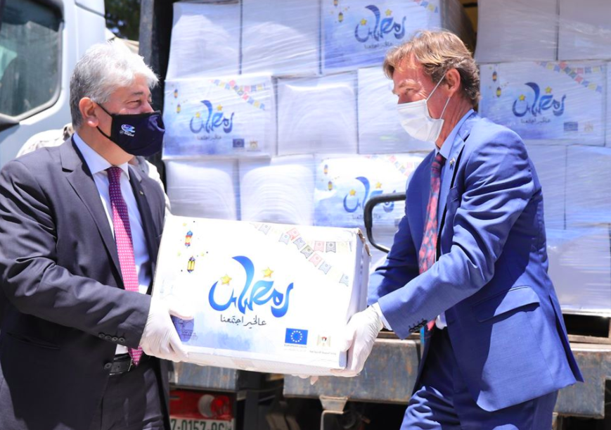 EU representative to the Palestinians Sven Kühn von Burgsdorff, right, hands more than 800 food packages to the PA's social development minister to be distributed to poor Palestinian families 