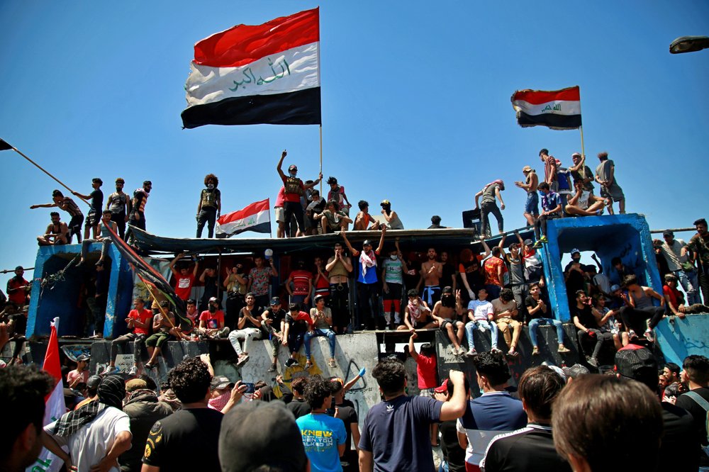Anti-government protesters stage a sit-in on barriers set up by security forces to close the Jumhuriyah Bridge leading to the Green Zone government area, during ongoing protests in Baghdad 
