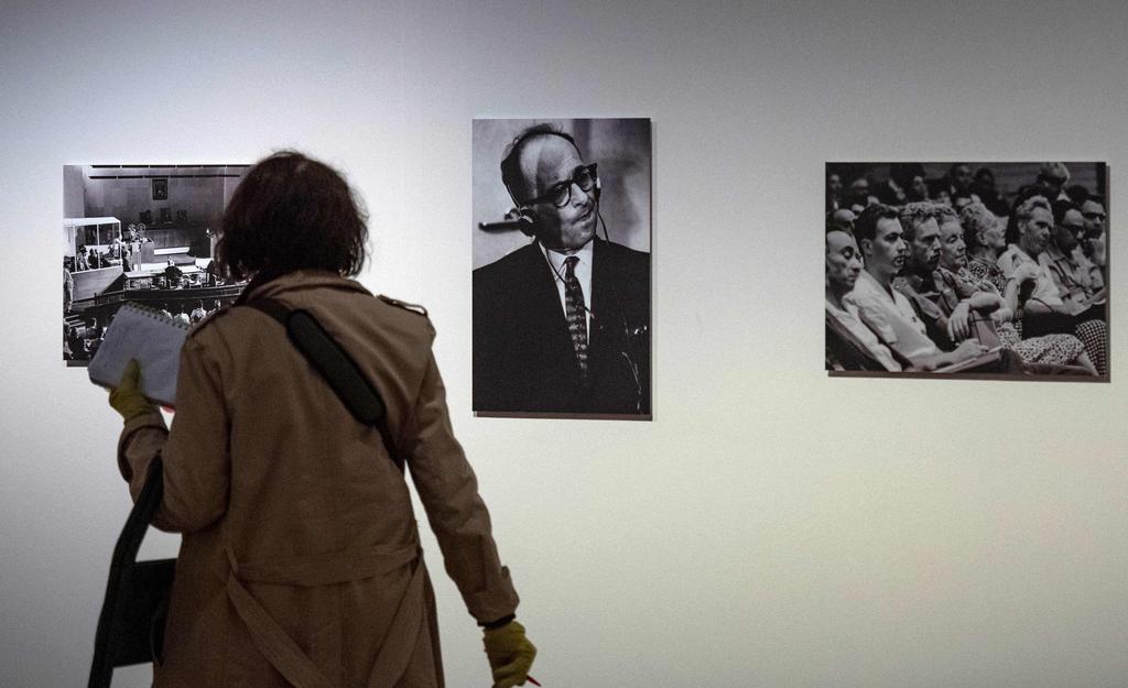 A visitor walks past a portrait of Nazi war criminal Adolf Eichmann (C) during his trial in Jerusalem at an exhibition on German-American philosopher and political theorist Hannah Arendt 