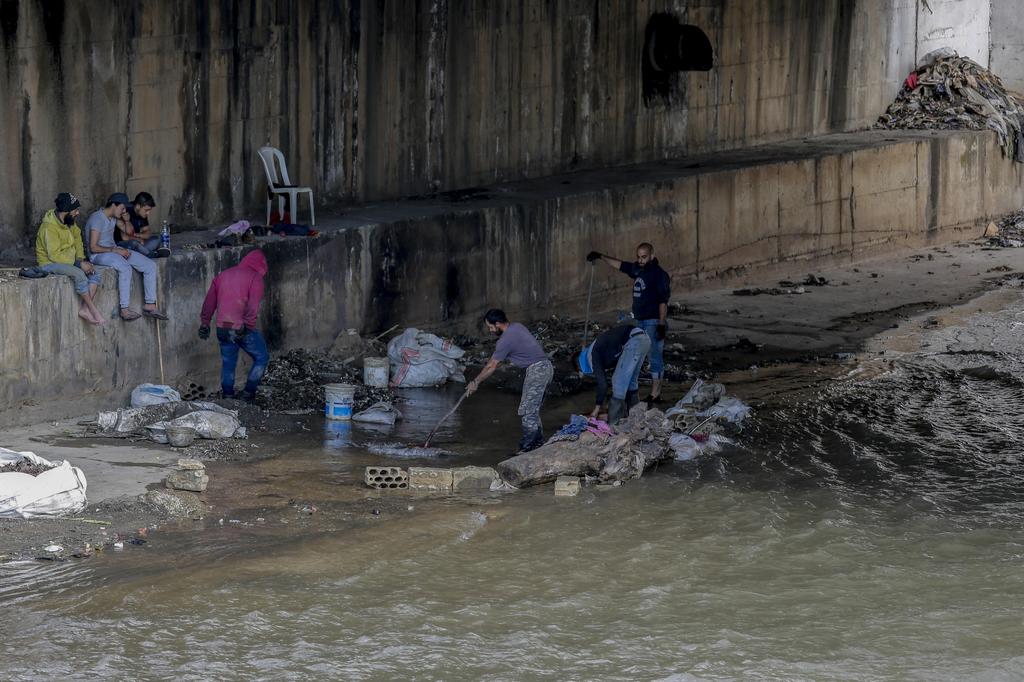 Men sifting through a sewer for valuables in Tripoli, Lebanon 