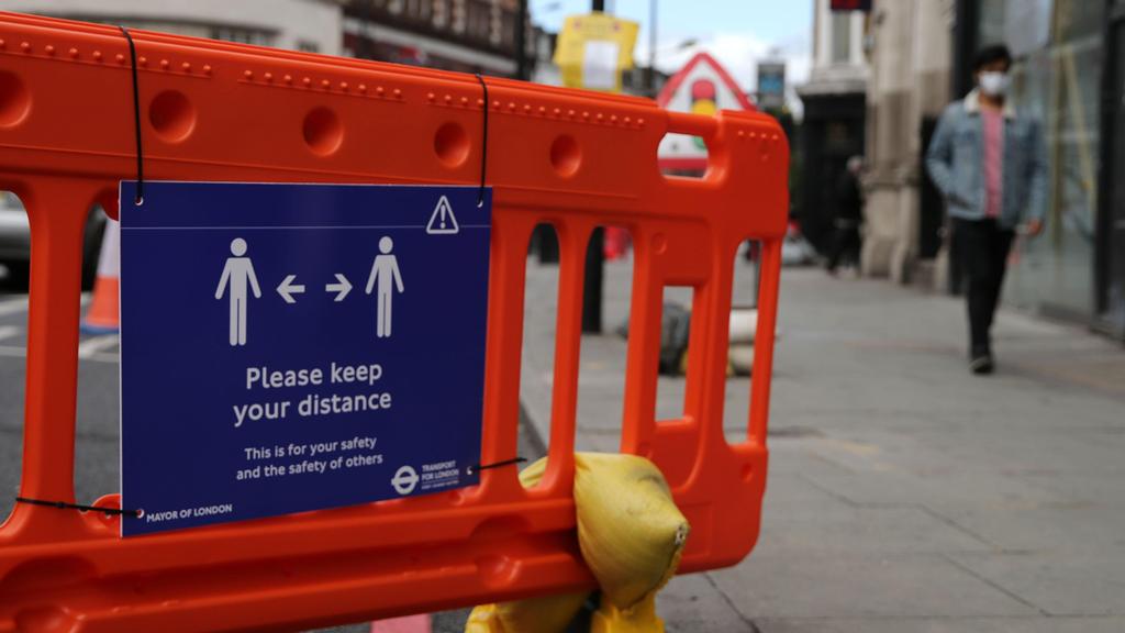 A sign is pictured encouraging people to use social distancing when using Camden High Street in central London on May 11, 2020 