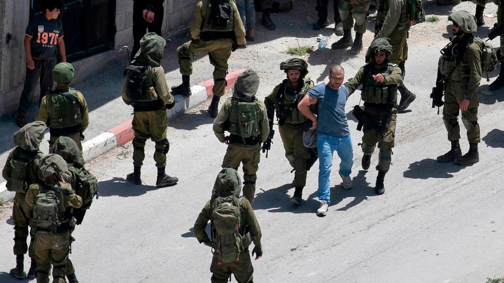 חיילים עוצרים פלסטיני לאחר שהחייל עמית בן יגאל נהרג בכפר יבעד