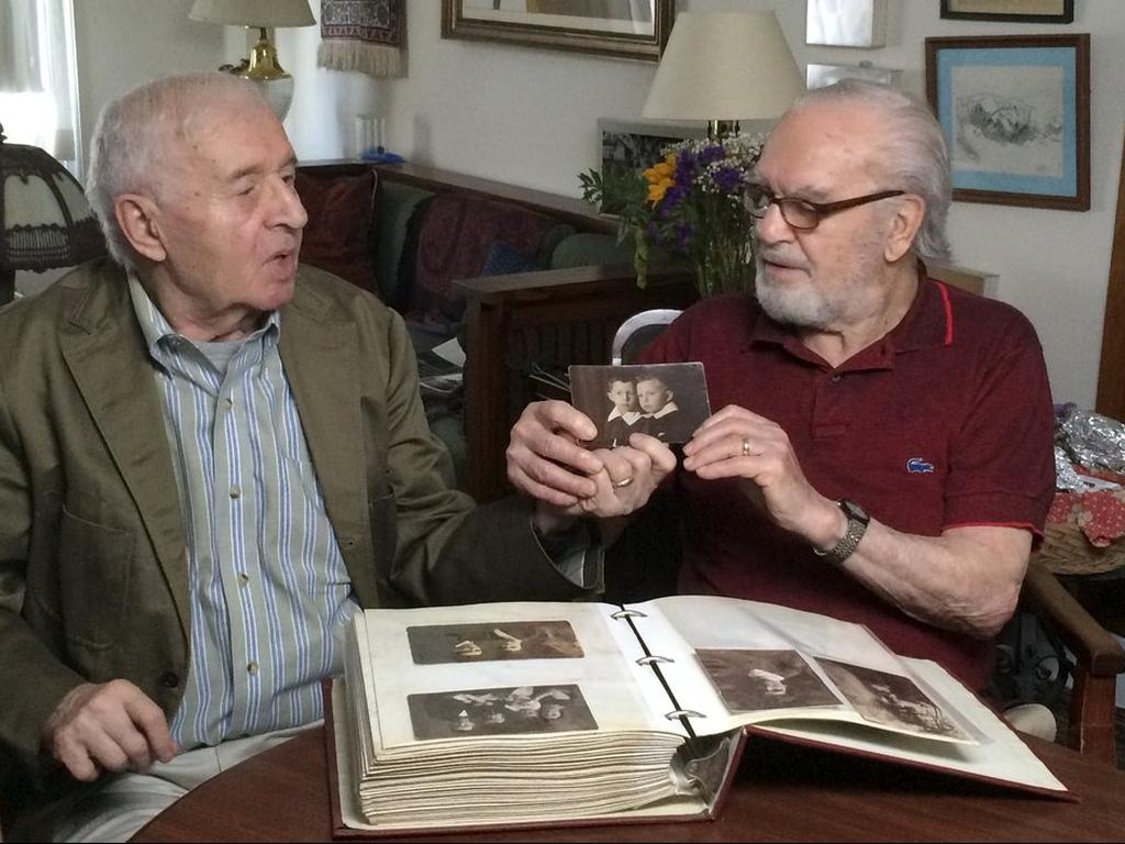 Brothers Alexander Feingold, left, and Joseph Feingold look at photo of themselves as boys in Joseph's apartment in New York 