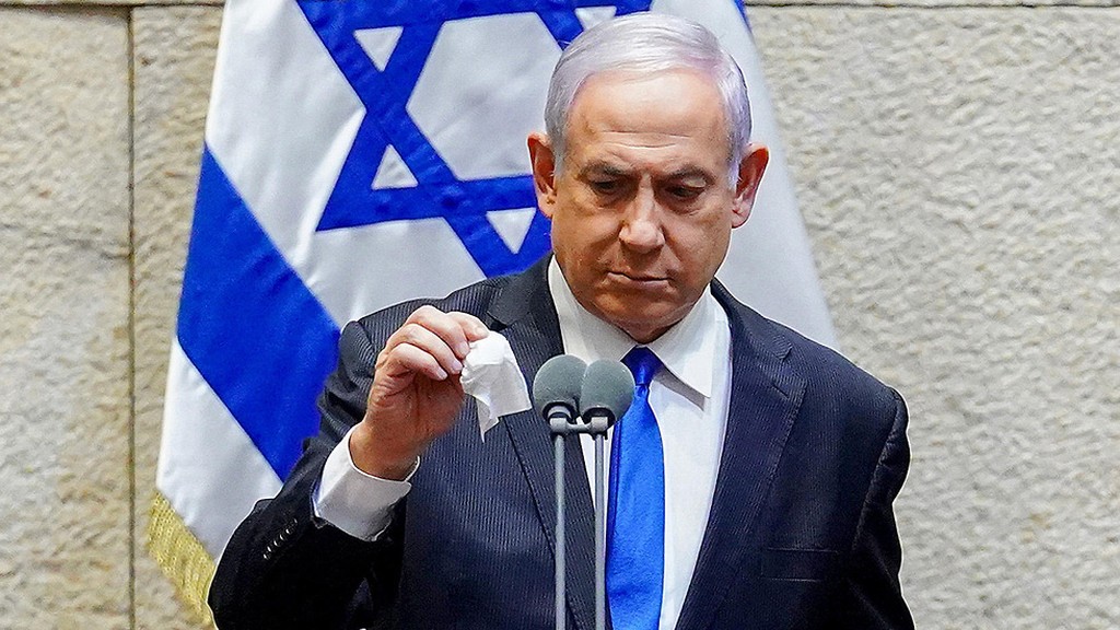 Prime Minister Benjamin Netanyahu disinfects the microphone before addressing the Knesset, May 2020 