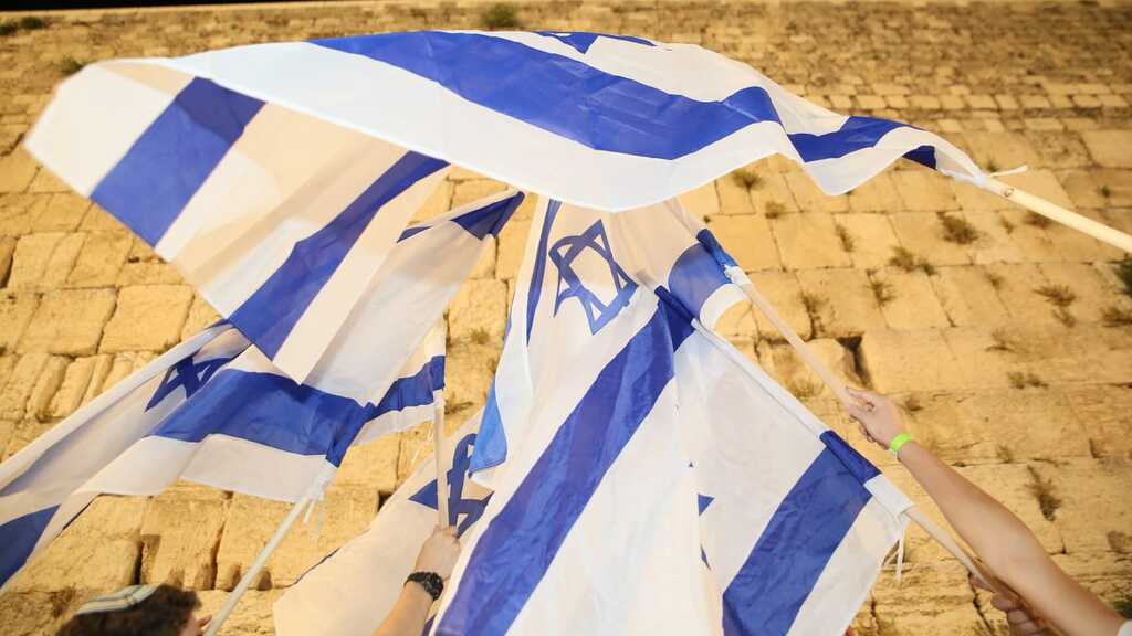  The Israeli flag held high at the Western Wall in Jerusalem 