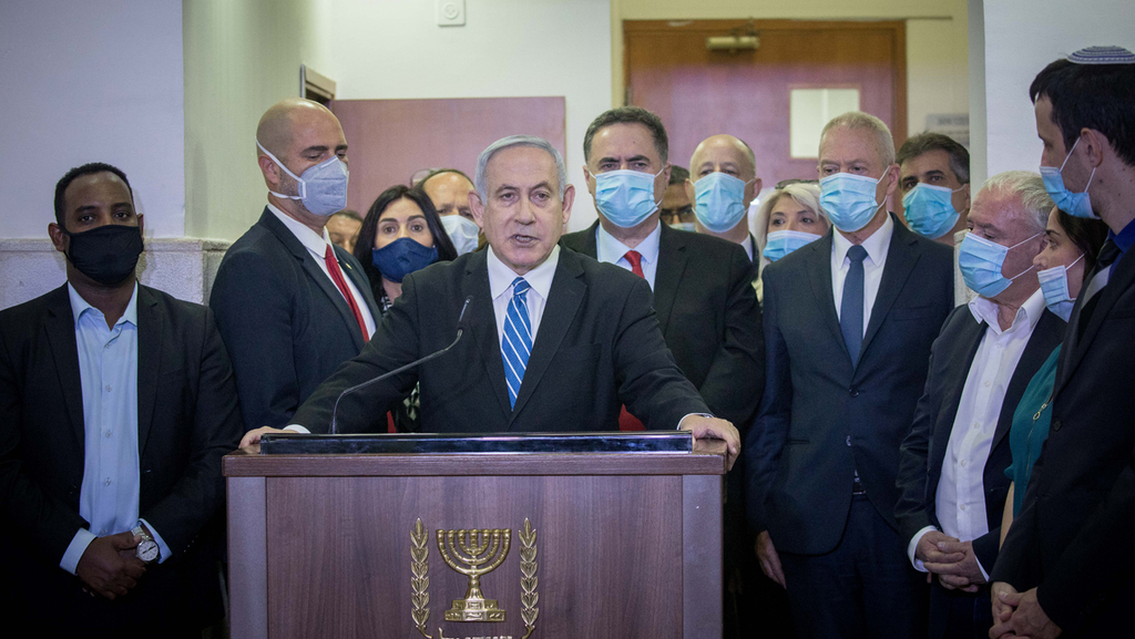 Flanked by Likud ministers and MKs, Benjamin Netanyahu attacks the judicial system at the start of his criminal trial in Jerusalem, May 2020 (Photo: Flash 90) בנימין נתניהו עם חברי הליכוד לפני הדיון הראשון במשפטו