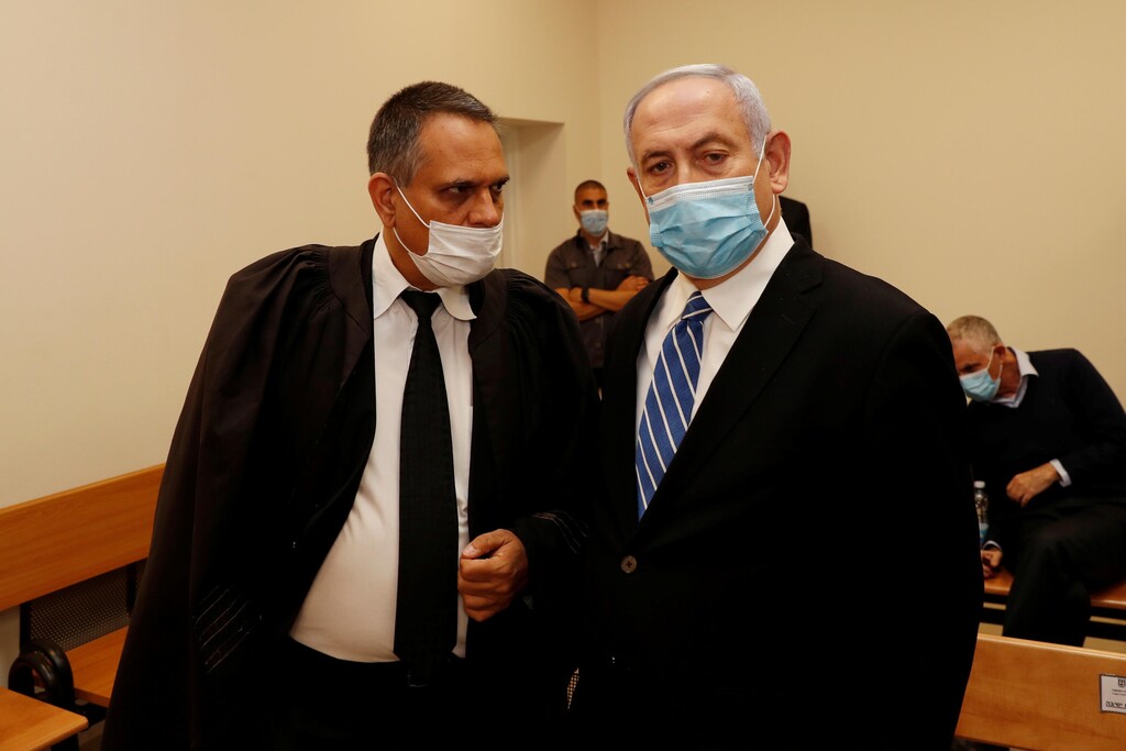 Prime Minister Benjamin Netanyahu stands inside the courtroom as his corruption trial opens at the Jerusalem District Court, May 24, 2020 