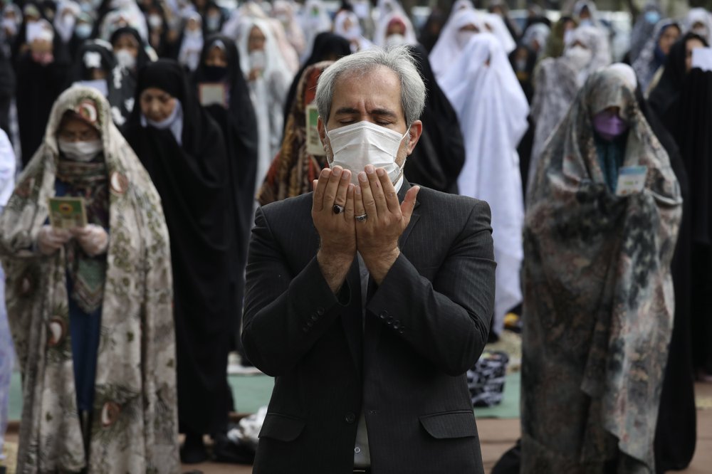Worshippers wearing protective face masks offer Eid al-Fitr prayers outside a mosque to help prevent the spread of the coronavirus, in Tehran, Iran 