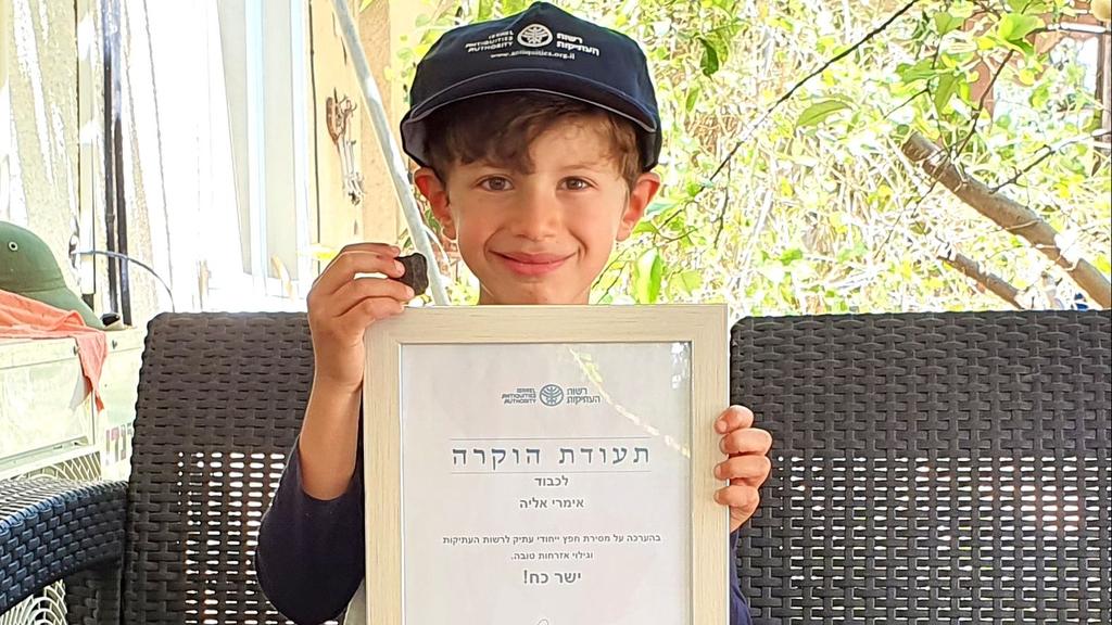 Imri Elya with his good citizenship certificate and the tablet (Photo: Israel Antiquities Authority ) אימרי אליה עם הלוחית הקדומה ותעודת ההוקרה שהעניקה לו רשות העתיקות