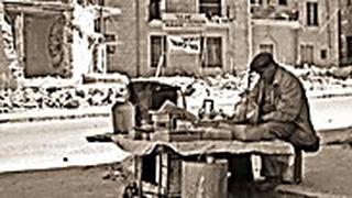 חנווני מסדר את מרכולתו ברחוב בן יהודה זמן קצר לאחר הפיגוע 1948