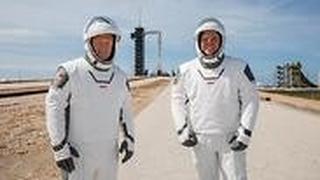 מדגמנים עתידנות. האסטרונאוטים בנקן (מימין) והארלי בחליפות החדשות על רקע כן השיגור עם טיל פלקון 