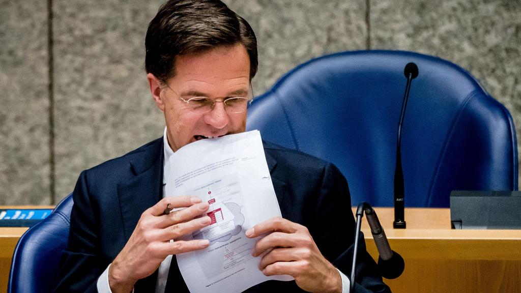 Dutch Prime Minister Mark Rutte holds documents during a parliamentary debate on the coronavirus crisis (COVID-19)