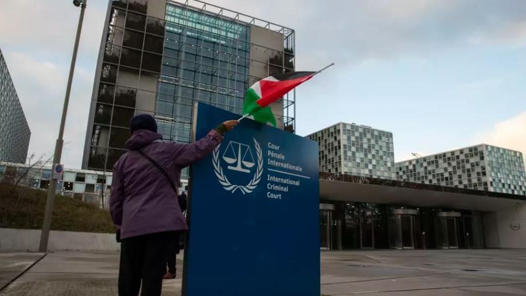 A demonstrator poses with a Palestinian flag outside the International Criminal Court
