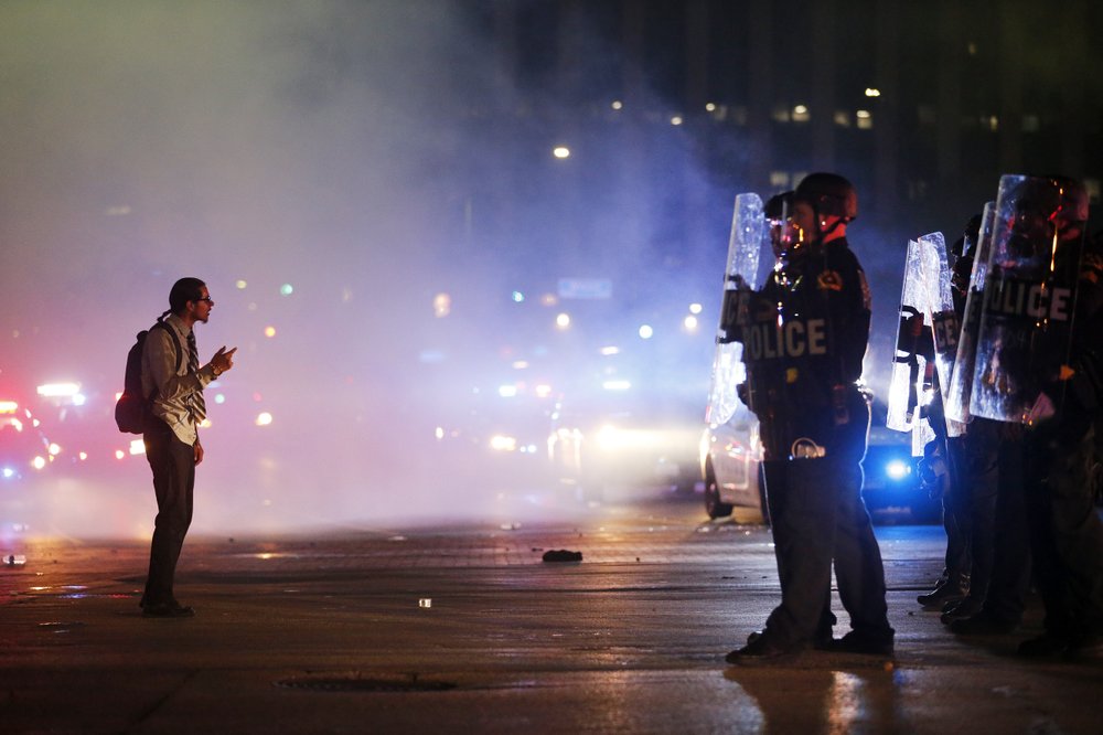 A protestor stands in the middle of the tear gas confronting tactical officers at the intersection of Young St. and S. Griffin St. in downtown Dallas 