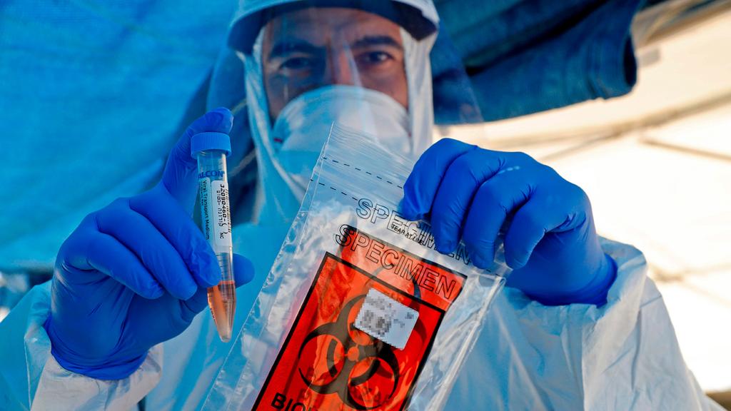 A health worker staffs a coronavirus testing site north of Tel Aviv 