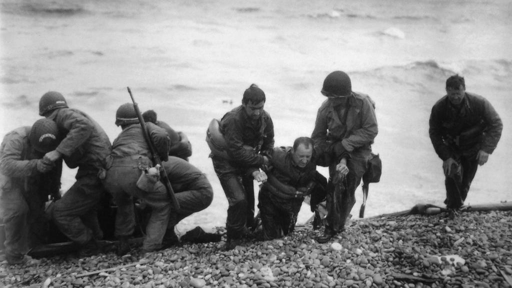 לוחמים אמריקנים מסייעים לחבריהם החלשים בחוף יוטה