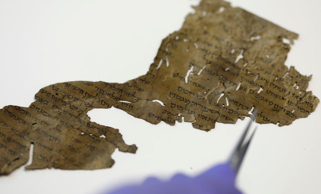 A conservator of Israeli Antiquities Authority shows fragments of the Dead Sea Scrolls at their laboratory in Jerusalem 