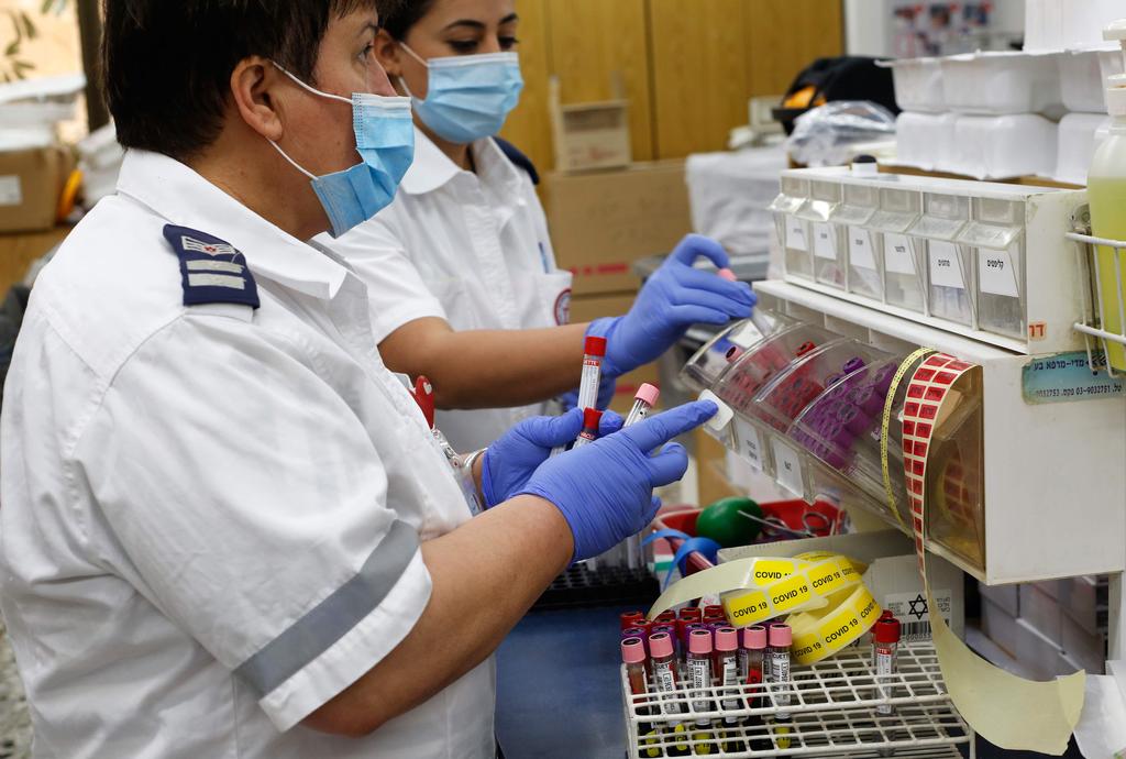 A medical worker holds a plasma sample extracted from blood donated by recovered coronavirus patients at Sheba Medical Center, June 1, 2020 