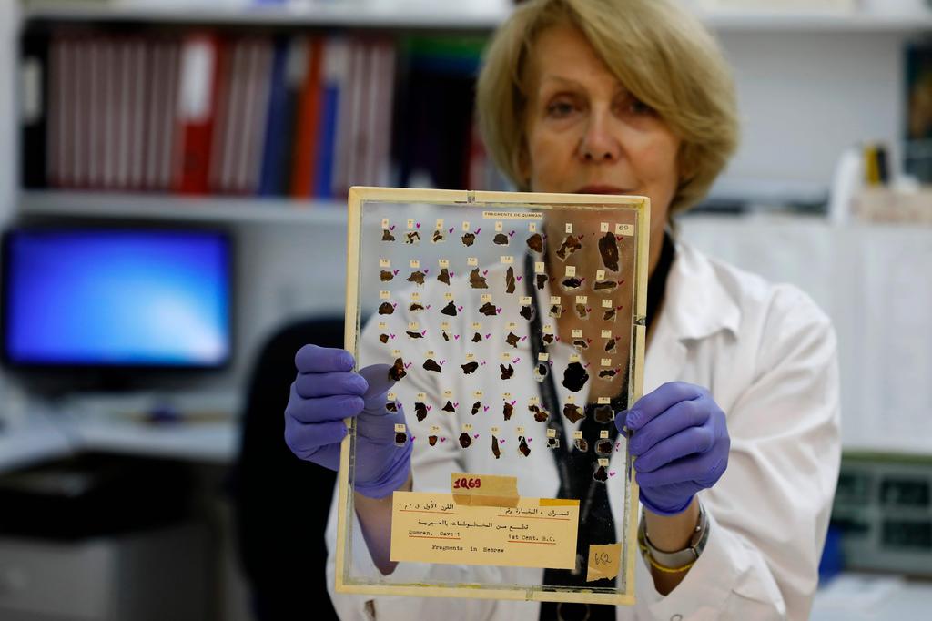 Tatyana Bitler, a conservator of Israeli Antiquities Authority, shows fragments of the Dead Sea Scrolls at their laboratory in Jerusalem 