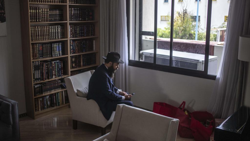 Rabbi Levi Banon takes a call as he sits in his home in Casablanca, Morocco