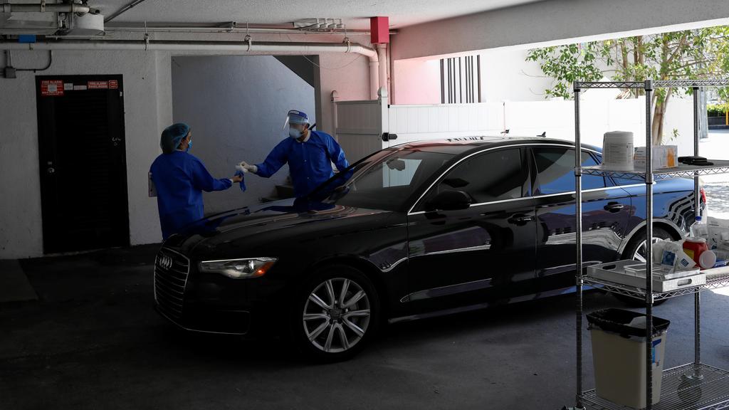 Michael Salzhauer, a plastic surgeon known as Dr. Miami, applies Botox to a patient while conducting drive-through Botox injections in the garage of his clinic 