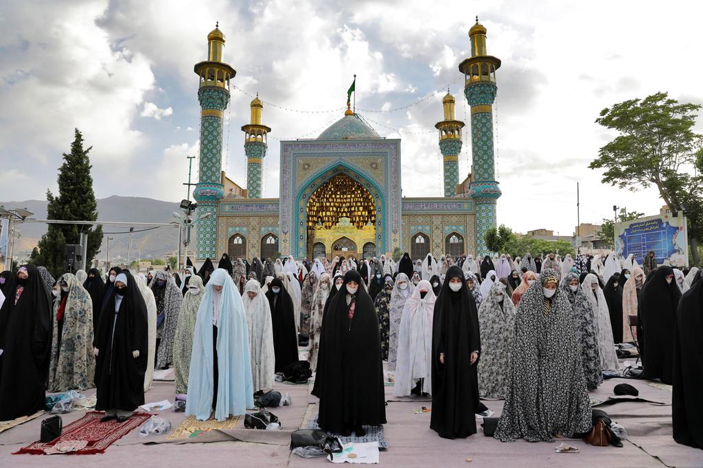 Shiite Muslim women wearing protective face masks while praying 