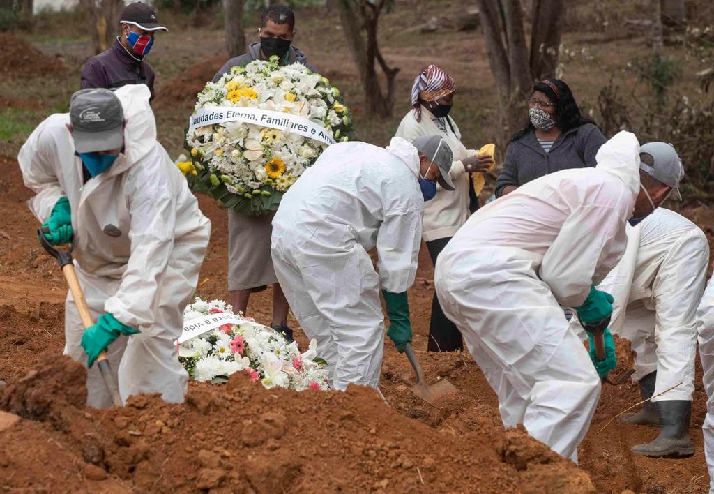 Undertakers in Brazil, wearing protective gear, bury coronavirus victims 