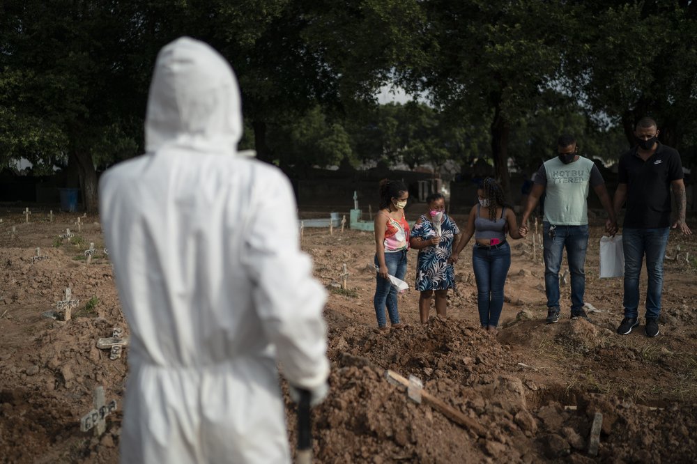 Relatives attend the burial of 57-year-old Paulo Jose da Silva, who died from the new coronavirus, in Rio de Janeiro, Brazil 
