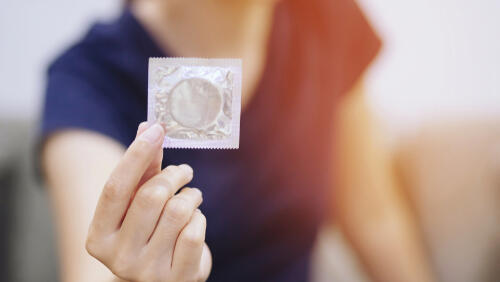 Дефицитный продукт (Фото: Shutterstock) אישה מחזיקה קונדום