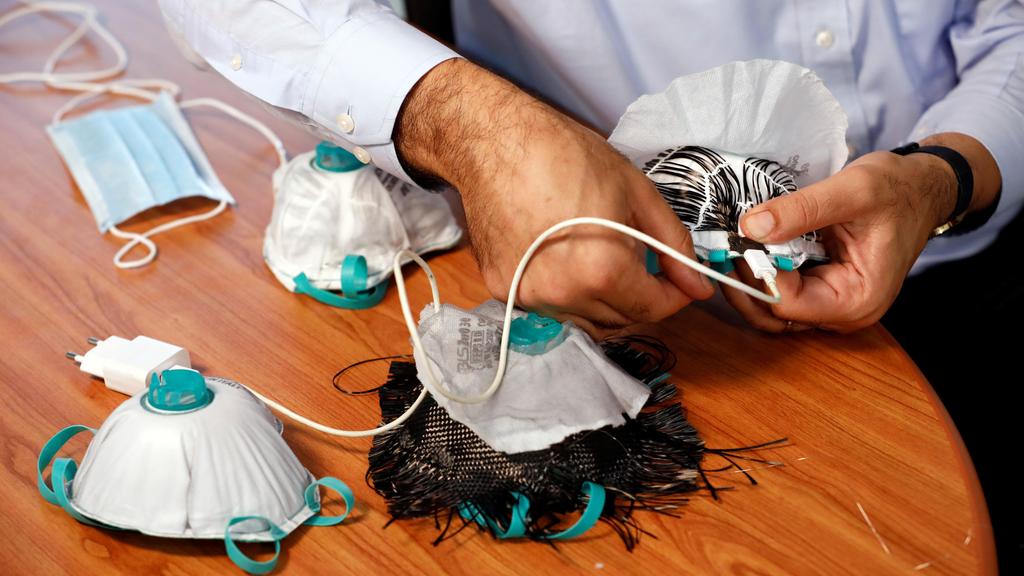 An Israeli researcher, part of a team which say they have invented a reusable face mask that can disinfect itself and kill the coronavirus disease (COVID-19), takes part in a demonstration 