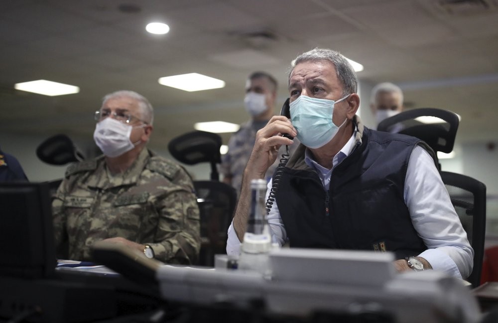 Turkish Defense Minister Hulusi Akar, right, and Chief of Staff Gen. Yasar Guler wearing face masks to protect against the coronavirus, monitor the operation at a military headquarters in Ankara, Turkey 